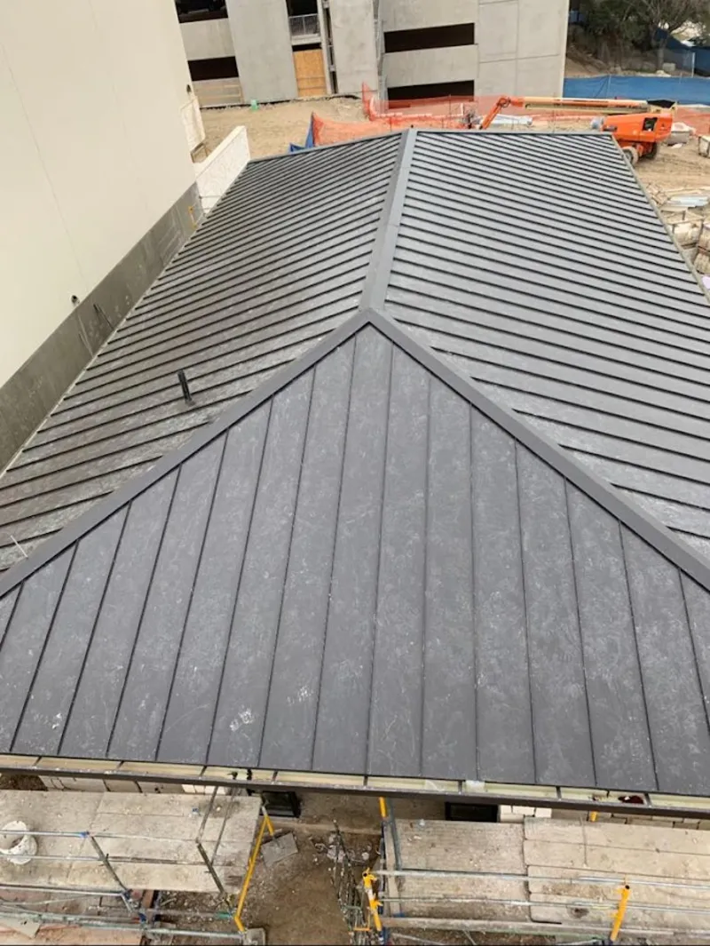 Commercial metal roof construction with crane equipment in Reedurban